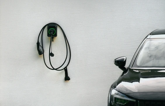 Scène extérieure urbaine avec véhicule électrique BMW i3 argenté en charge via borne de recharge publique