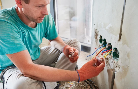 Électricien Avec Apprentis Travaillant Dans Une Nouvelle Maison